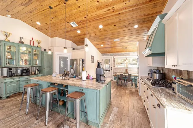 a view of a kitchen with stainless steel appliances granite countertop a stove and cabinets
