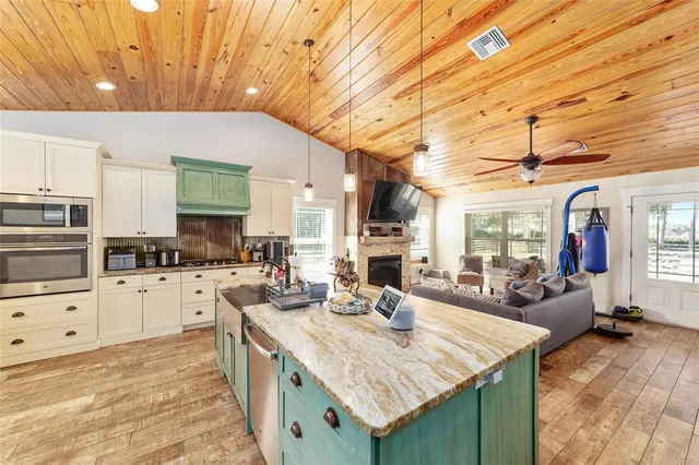 a room with lots of white furniture and a chandelier