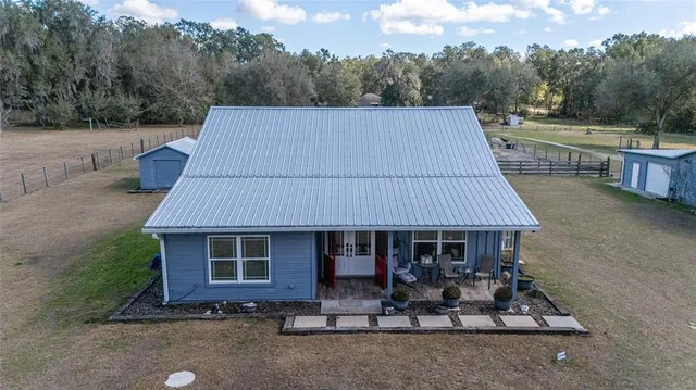 an aerial view of a house with a yard and lake view