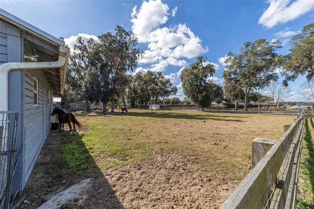 a front view of a house with a garden and trees
