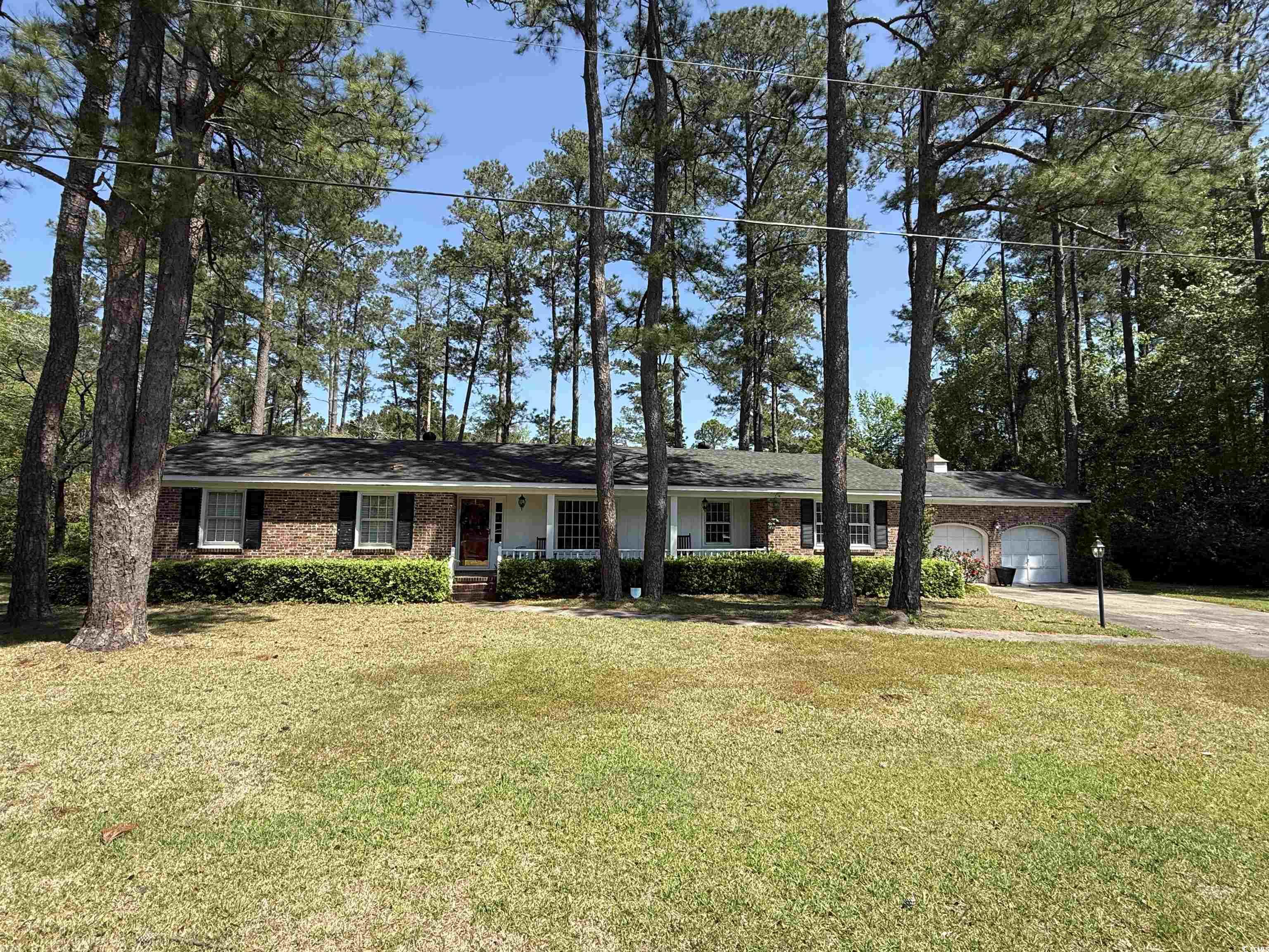 Ranch-style home with a front yard, driveway, and a garage