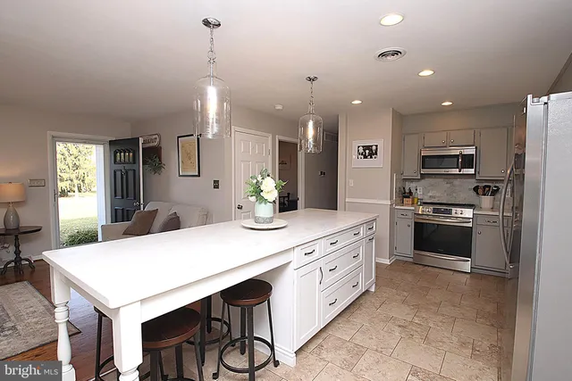 a kitchen with kitchen island a sink stainless steel appliances and cabinets
