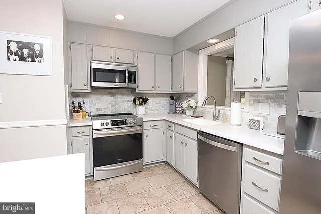 a kitchen with stainless steel appliances granite countertop a sink and a stove