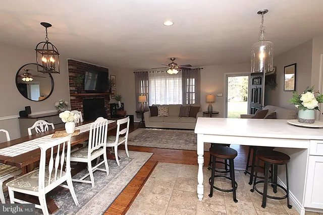 a dining room with furniture a chandelier and kitchen view