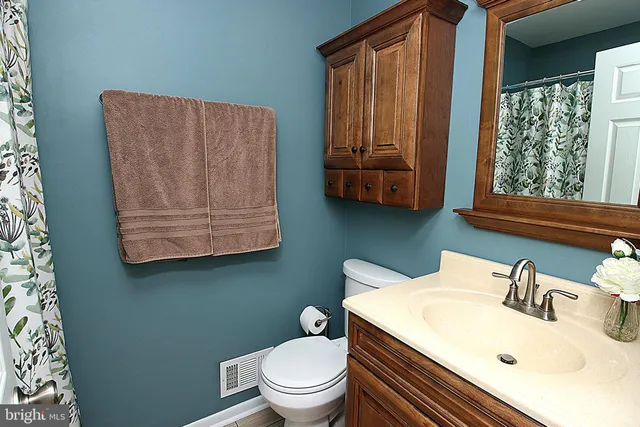a bathroom with a toilet sink and mirror