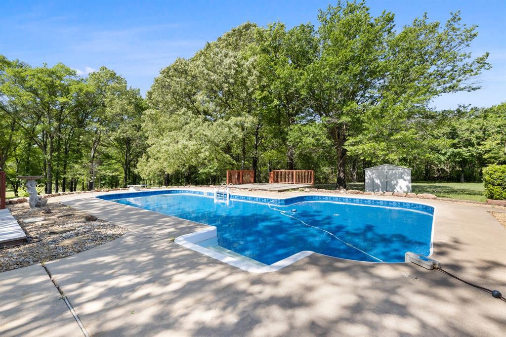 321 Vz County Road 2602 Wills Point, TX 75169 - Photo 31 of 39 Pool with a diving board, an outdoor structure, and a storage unit