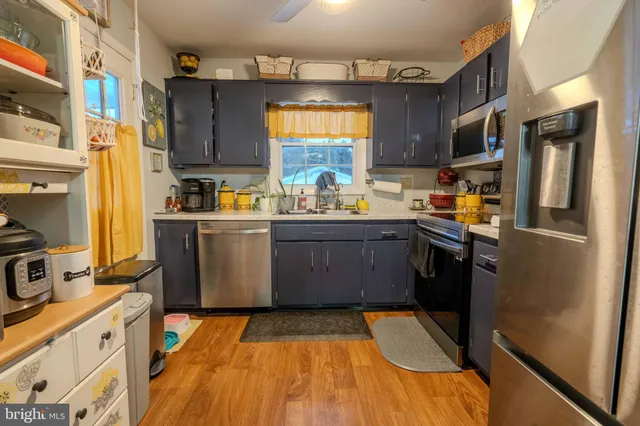 a kitchen with stainless steel appliances granite countertop a stove a sink dishwasher and a refrigerator