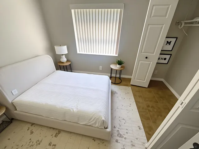 a bedroom with a bed and a large window