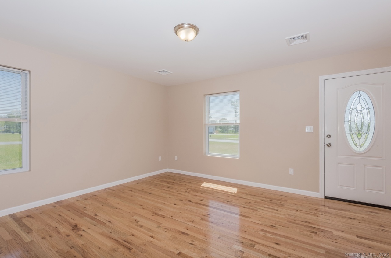 13 Nature Avenue, Unit A Colchester, CT 06415 - Photo 17 of 34 an empty room with wooden floor and windows
