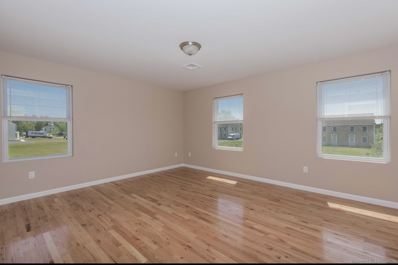 13 Nature Avenue, Unit A Colchester, CT 06415 - Photo 20 of 34 a view of an empty room with wooden floor and a window