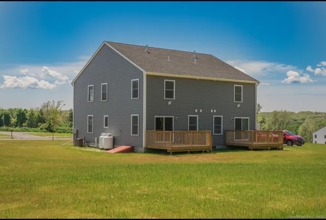 a front view of house with yard and trees in the background