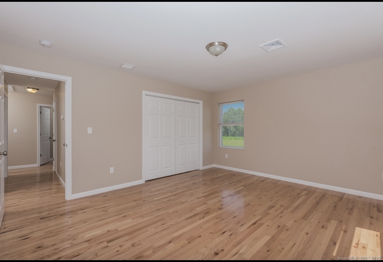 13 Nature Avenue, Unit A Colchester, CT 06415 - Photo 21 of 34 a view of an empty room with wooden floor and a window