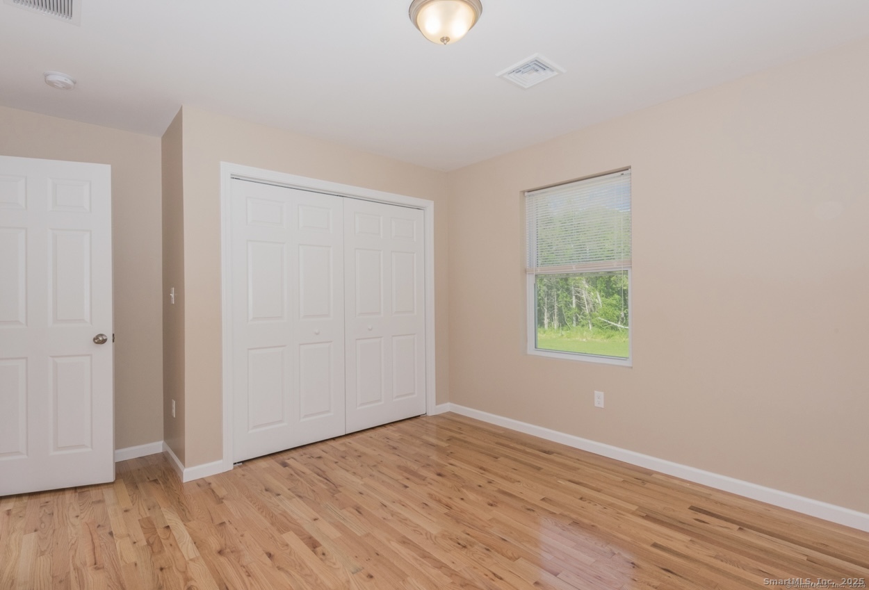 13 Nature Avenue, Unit A Colchester, CT 06415 - Photo 26 of 34 a view of an empty room with wooden floor and a window