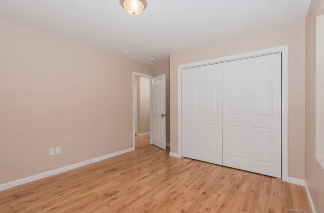 a view of an empty room with wooden floor