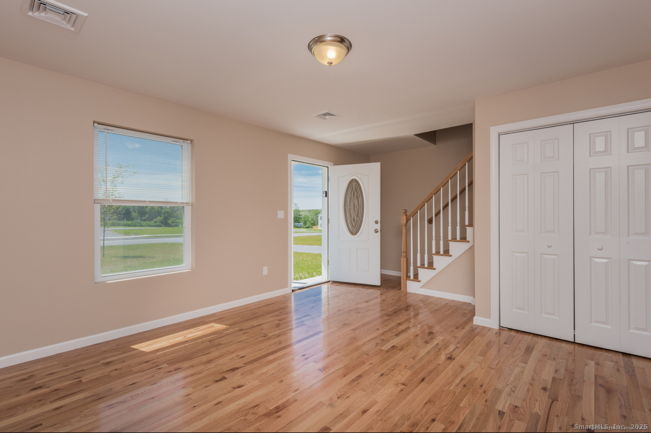 13 Nature Avenue, Unit A Colchester, CT 06415 - Photo 3 of 34 a view of an empty room with wooden floor and a window