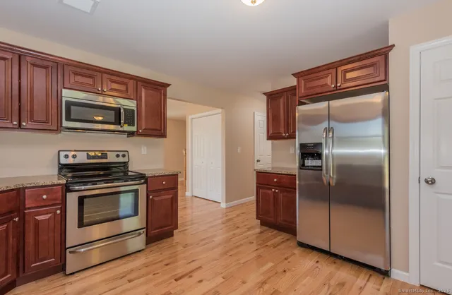 a kitchen with wooden cabinets and stainless steel appliances
