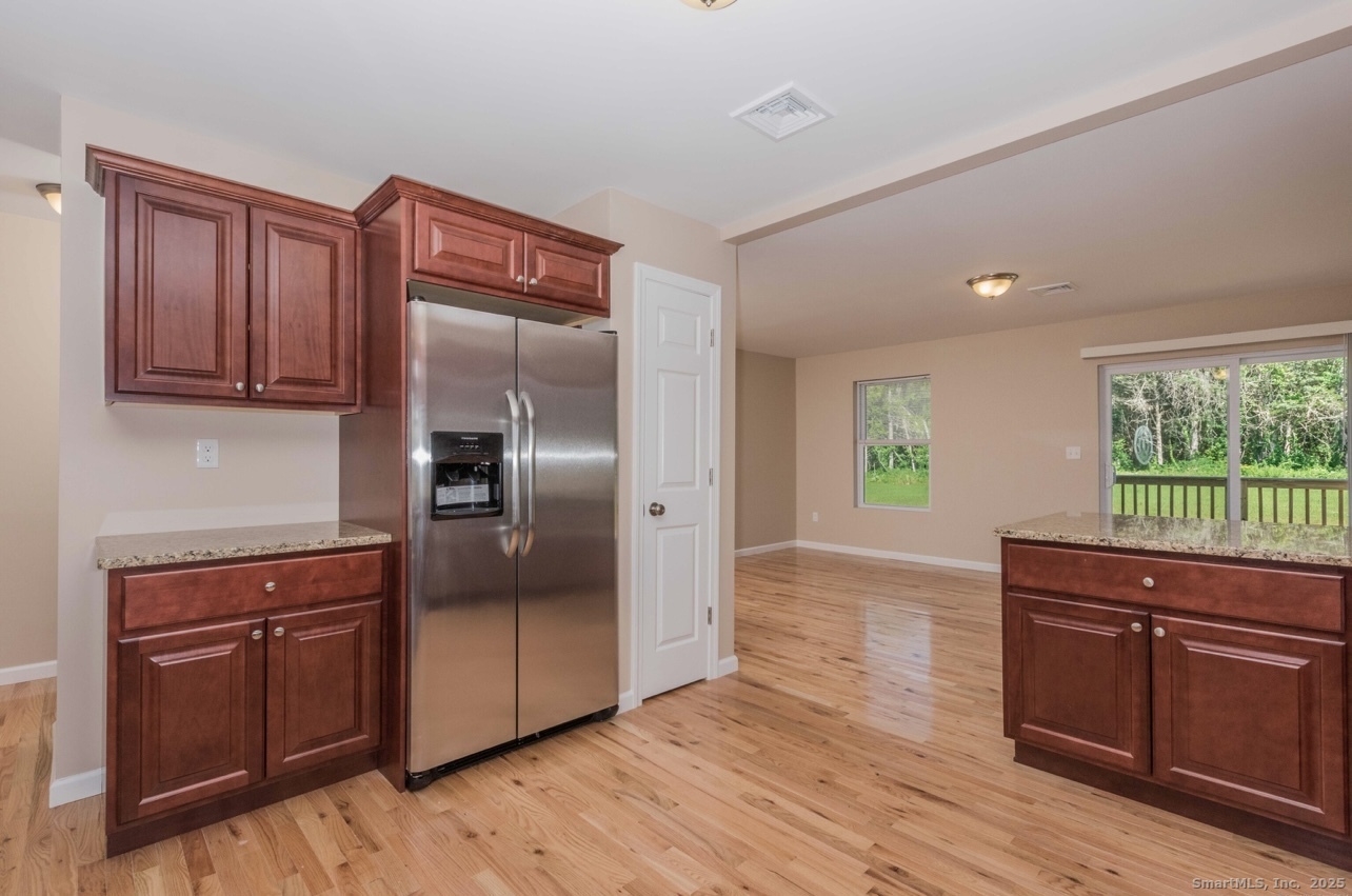 13 Nature Avenue, Unit A Colchester, CT 06415 - Photo 10 of 34 a kitchen with stainless steel appliances granite countertop a refrigerator sink and wooden cabinets