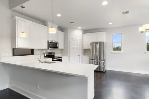 a kitchen with stainless steel appliances a refrigerator sink and microwave