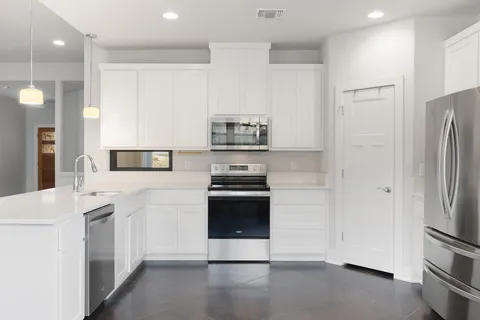 a kitchen with stainless steel appliances a refrigerator stove and sink