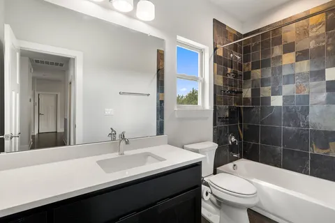 a bathroom with a sink a toilet a shower and a mirror