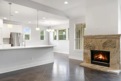 a open kitchen with a fireplace and wooden floor