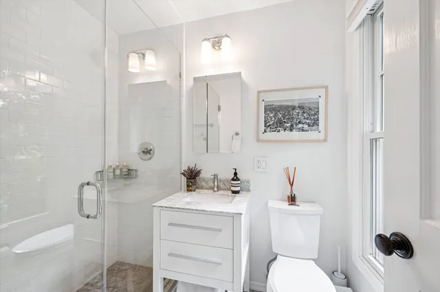 a bathroom with a sink a toilet and shower