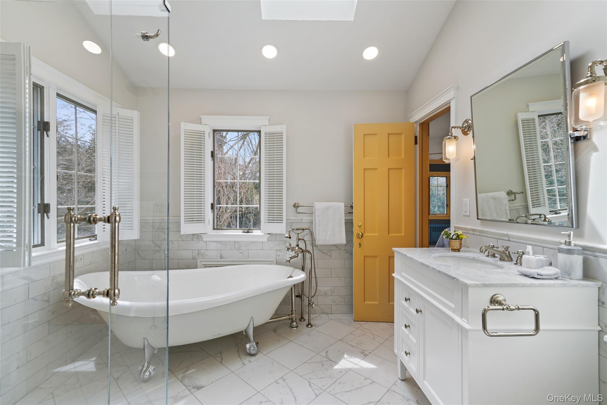 49 Moore Road Bronxville, NY 10708 - Photo 25 of 46 a spacious bathroom with a tub sink and mirror