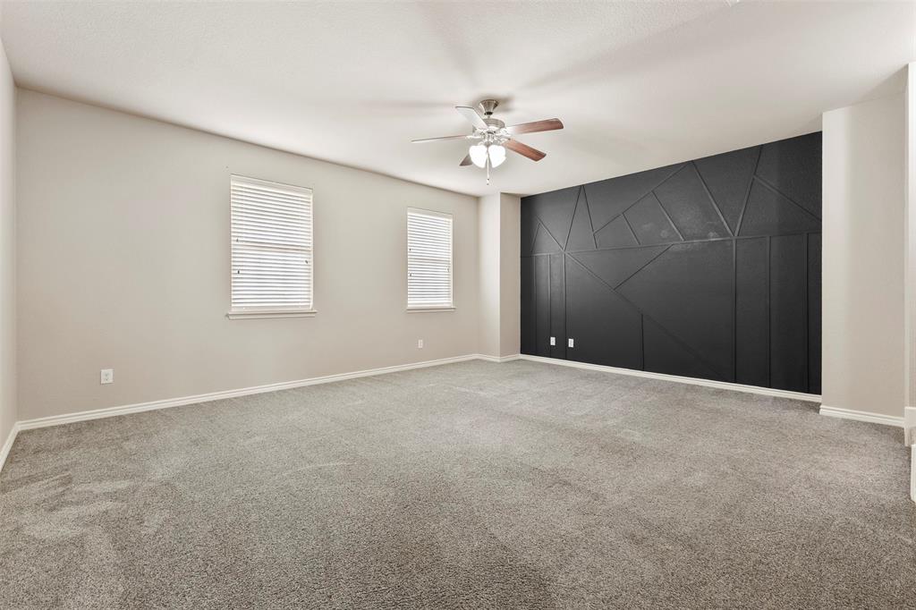 6522 Portside Ridge Lane Dallas, TX 75249 - Photo 13 of 37 Spacious room featuring a decorative accent wall with geometric paneling