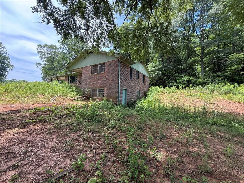 a house is sitting in middle of the green field