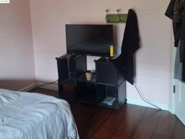 a bedroom with a bed and a flat tv screen on a dresser