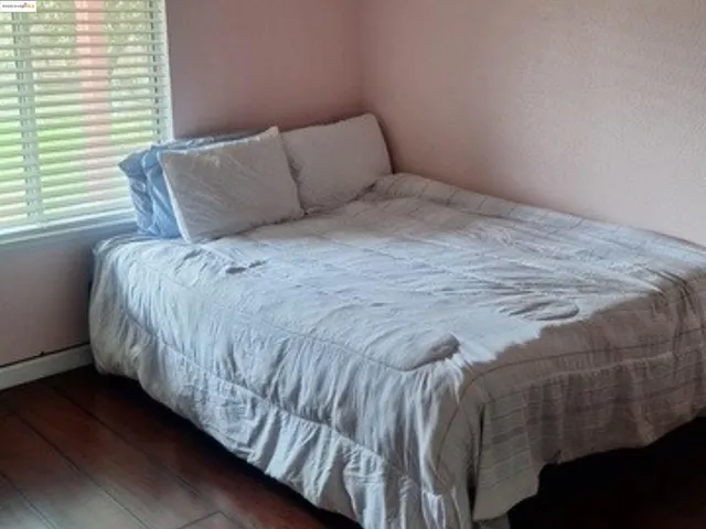 a bed sitting in a bedroom next to a window
