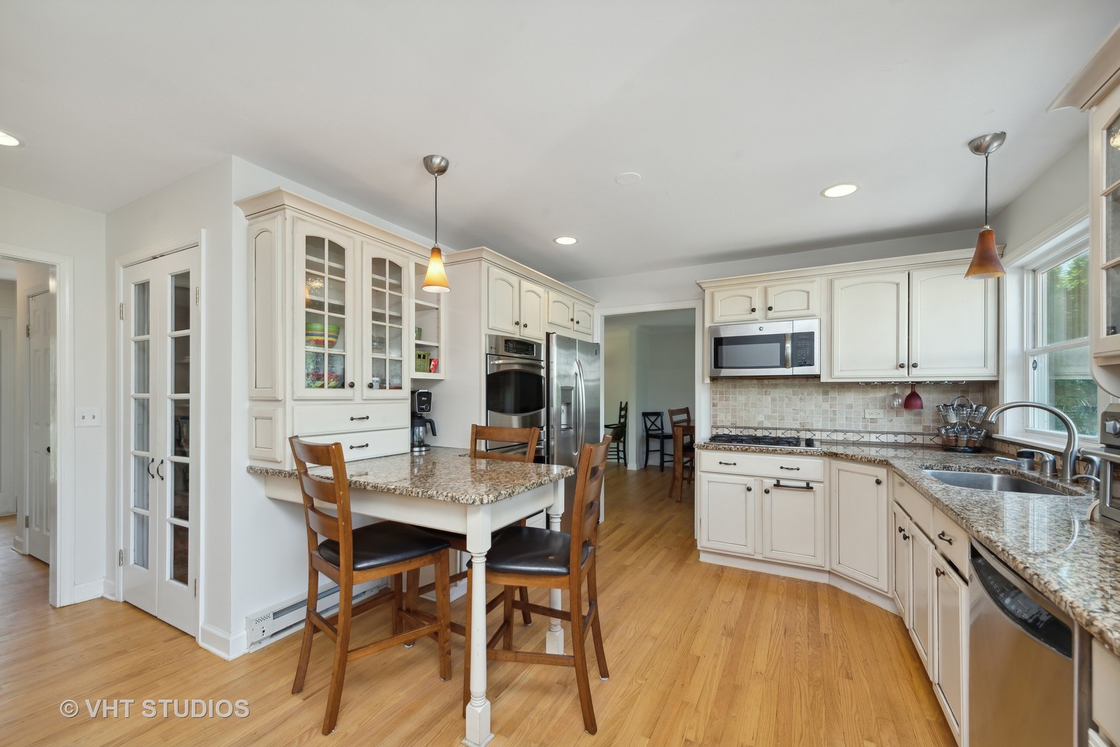 237 Valley Road Trout Valley, IL 60013 - Photo 6 of 48 a open kitchen with stainless steel appliances granite countertop a stove top oven a sink dishwasher a dining table and chairs with wooden floor