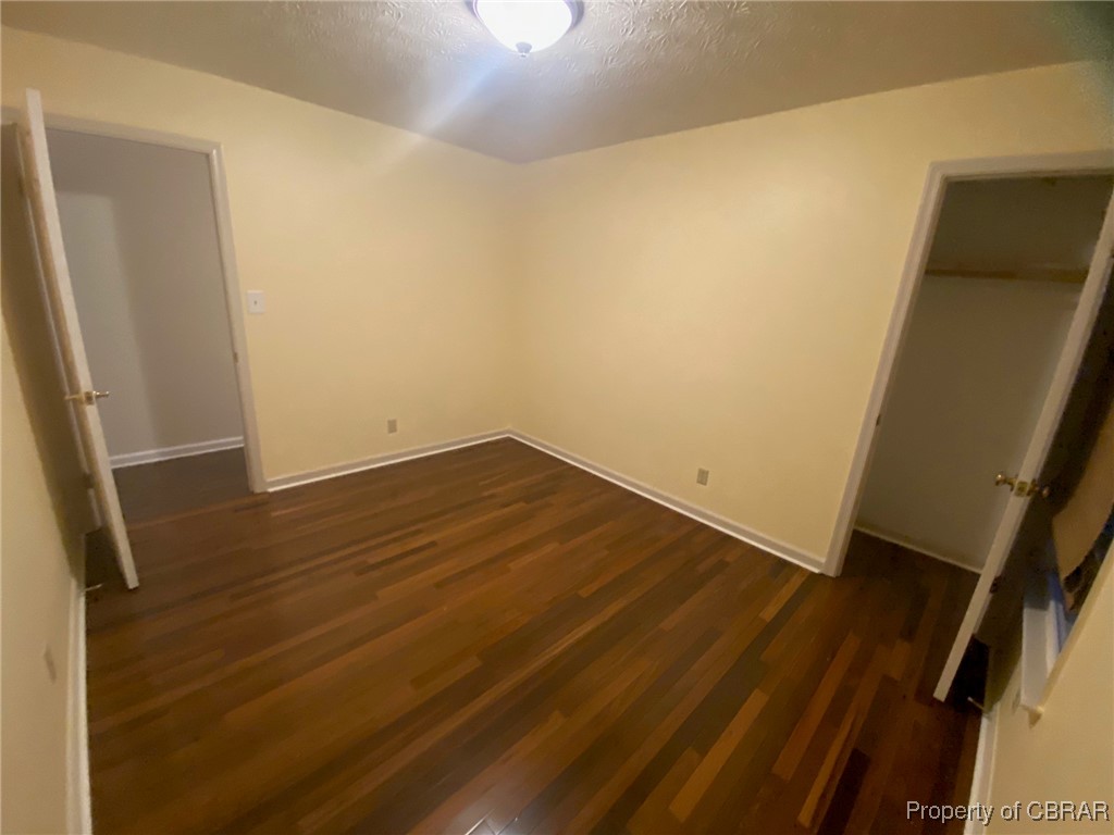 7944 Terrapin Cove Road Gloucester Point, VA 23062 - Photo 20 of 33 Unfurnished bedroom with a textured ceiling, dark hardwood / wood-style floors, and a closet