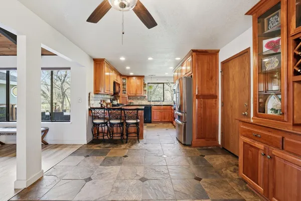 a open kitchen with stainless steel appliances granite countertop a refrigerator and a sink