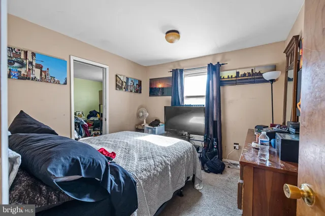 a bedroom with a bed dresser and a window