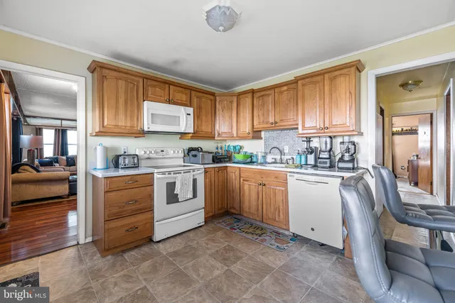 a kitchen with granite countertop a stove top oven a sink dishwasher and cabinets with wooden floor