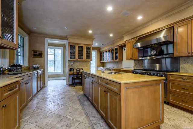 a kitchen with stainless steel appliances granite countertop a stove top oven a sink a counter space and cabinets