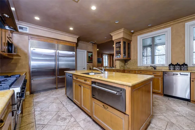 a kitchen with kitchen island granite countertop a sink stainless steel appliances and cabinets
