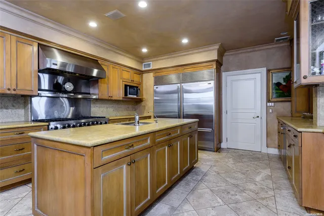a kitchen with stainless steel appliances granite countertop a stove a sink and a refrigerator