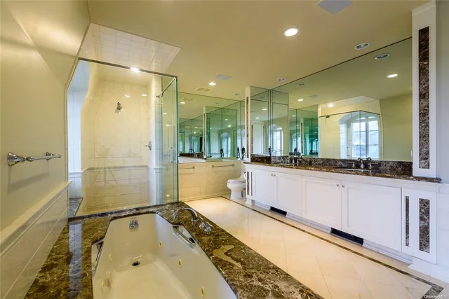 a bathroom with a tub a double vanity sink and mirror