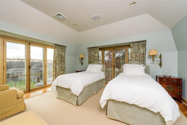 a spacious bedroom with two large bed and a large window