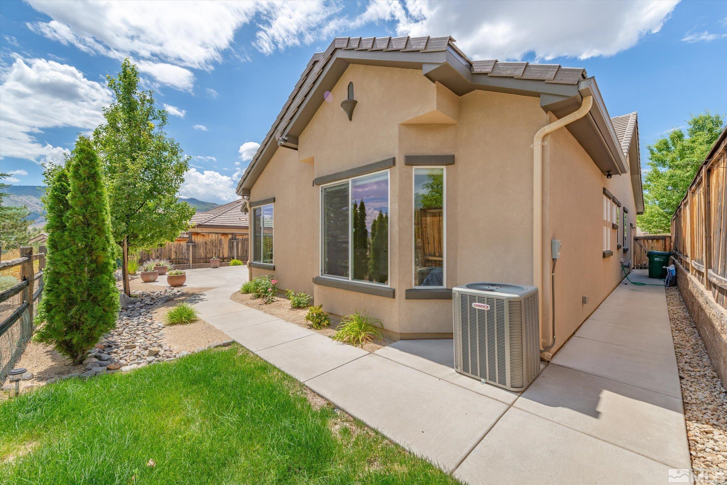 1310 Winterchase Way Reno, NV 89523 - Photo 35 of 38 a view of a white house with a small yard plants and a large tree