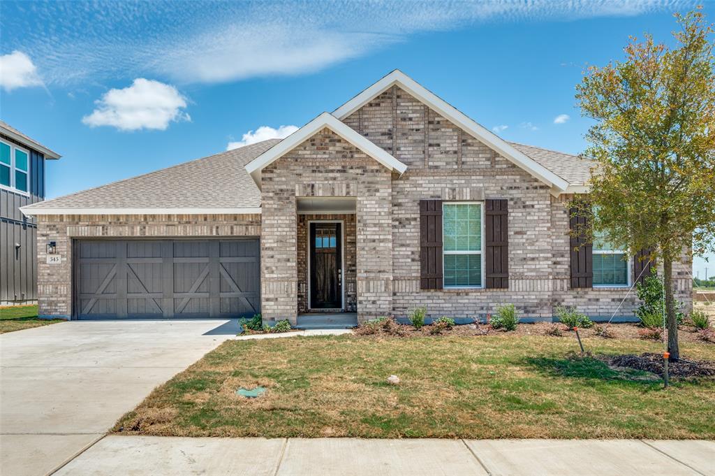 View of front of home featuring brick siding, an attached garage, driveway, and a front lawn
