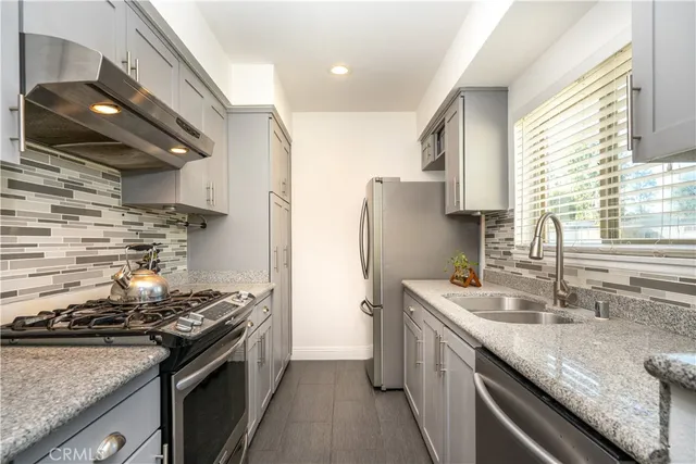 a kitchen with stainless steel appliances granite countertop a sink stove and cabinets
