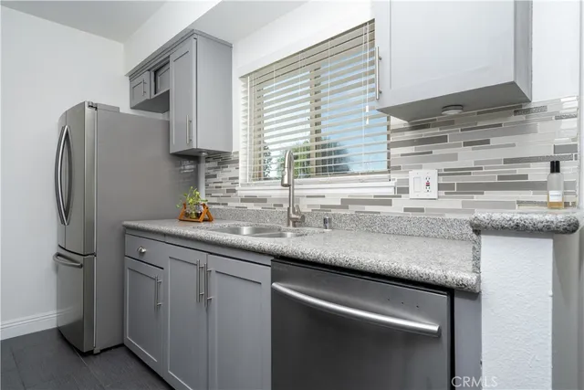 a kitchen with stainless steel appliances granite countertop a sink and a refrigerator