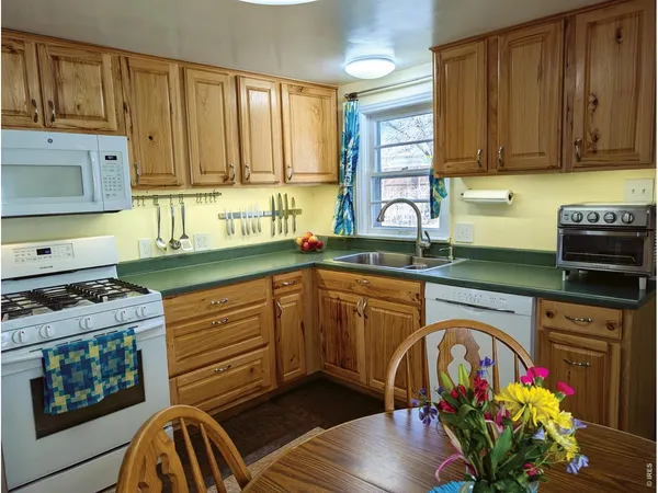 a kitchen with stainless steel appliances granite countertop a stove top oven a sink dishwasher and cabinets with wooden floor