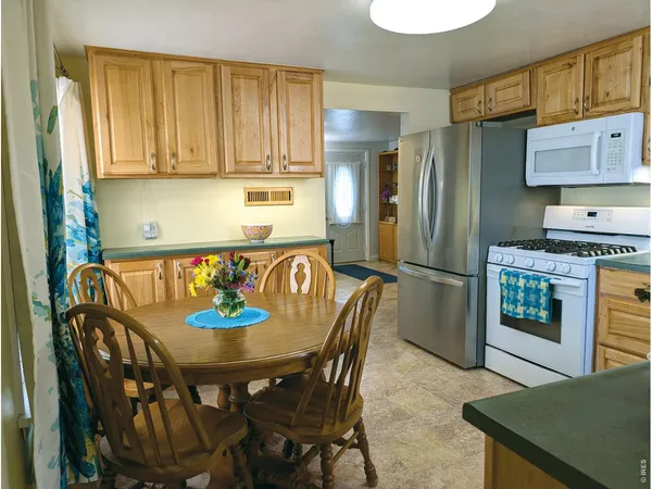 a kitchen with stainless steel appliances granite countertop a dining table and chairs