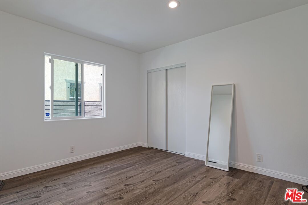 3447 9th Avenue Los Angeles, CA 90018 - Photo 13 of 18 an empty room with wooden floor and windows