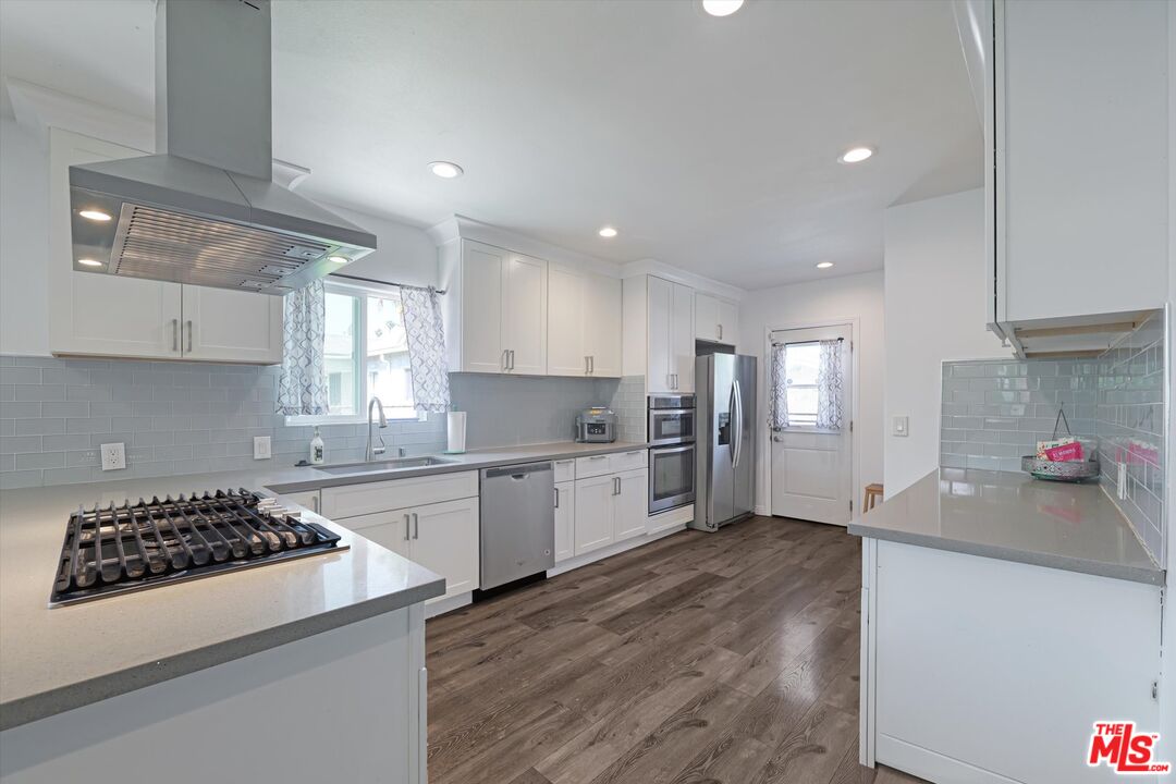 3447 9th Avenue Los Angeles, CA 90018 - Photo 7 of 18 a kitchen with a sink a stove and cabinets