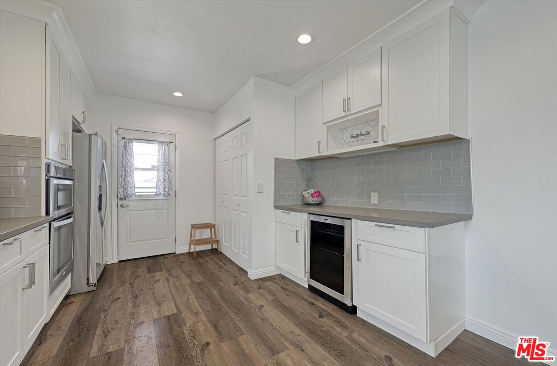 3447 9th Avenue Los Angeles, CA 90018 - Photo 8 of 18 a kitchen with white cabinets and stainless steel appliances